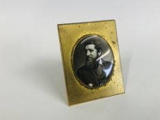 AN ANTIQUE PORCELAIN OVAL PORTRAIT PLAQUE IN A BRASS SURROUND (A/F SMALL CHIP),