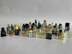 A BOX CONTAINING A LARGE MIXTURE OF MIXED MINIATURE GENTS PERFUMES INCLUDING TALPH LAUREN, BOSS,