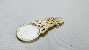 A VINTAGE MOTHER OF PEARL INTRICATELY CARVED CADDY / CAVIAR SPOON.