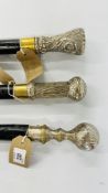 THREE EBONY FINISH WALKING CANES WITH ORNATE WHITE METAL FINNIALS.