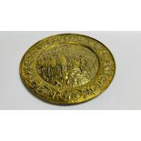 A LARGE BRASS EMBOSSED CHARGER DEPICTING GRECIAN MEN ON HORSE BACK 56.5CM DIAMETER.