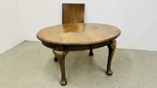 AN ANTIQUE OAK OVAL EXTENDING DINING TABLE ON PAD FEET.
