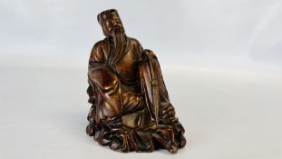 AN ORIENTAL CARVED HARDWOOD FIGURE OF A SEATED ELDER, 14CM HIGH.