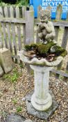 A CLASSICAL DESIGNED CONCRETE BIRD BATH WITH A PAN PLAYING THE FLUTE ON A LARGE COLUMN BASE,