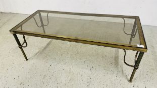 A VINTAGE BRASS FRAMED COFFEE / OCCASIONAL TABLE ON REEDED SUPPORTS INSET WITH GLASS - 107CM X 46.