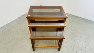 A NEST OF 3 MID CENTURY STYLE TABLES WITH CLEAR GLASS INSERTS.