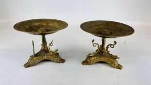 A PAIR OF ELABORATE BRASS TAZZA'S SUPPORTED BY DOLPHINS H 17.5CM, DIAM 23CM.
