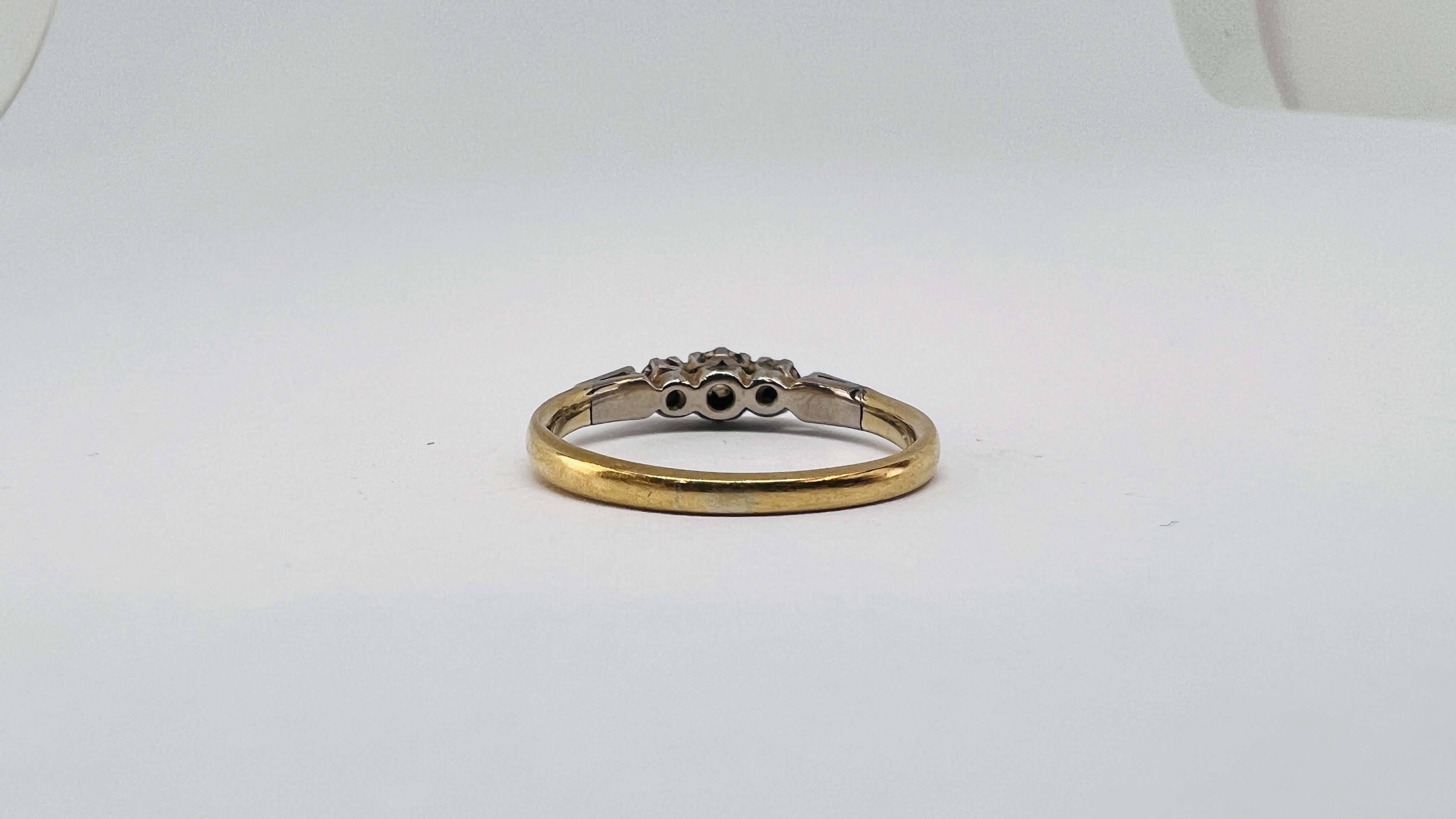A YELLOW METAL 3 STONE DIAMOND RING (RUBBED MARKS). - Image 6 of 9