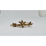 A VINTAGE 15CT GOLD FLOWER BROOCH SET WITH SEED PEARLS.