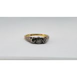 A YELLOW METAL 3 STONE DIAMOND RING (RUBBED MARKS).