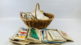A WICKER BASKET CONTAINING A COLLECTION OF VINTAGE DRESS MAKERS PATTERNS.