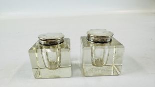 A PAIR OF VINTAGE GLASS INKWELLS HAVING SILVER HINGED TOPS J.G. & S - H 5CM.