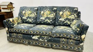 A TWO SEATER SOFA AND A THREE SEATER SOFA FITTED WITH LOOSE COVERS DECORATED WITH ORIENTAL FLOWERS