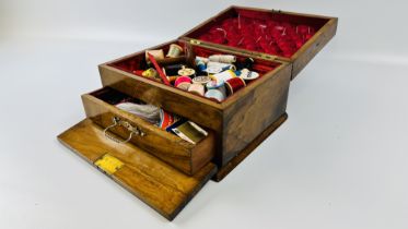 AN ANTIQUE WALNUT SEWING BOX AND CONTENTS TO INCLUDE COTTON REELS, THIMBLES AND ACCESSORIES.