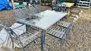 A GLASS TOP GARDEN TABLE AND 6 METAL CHAIRS.