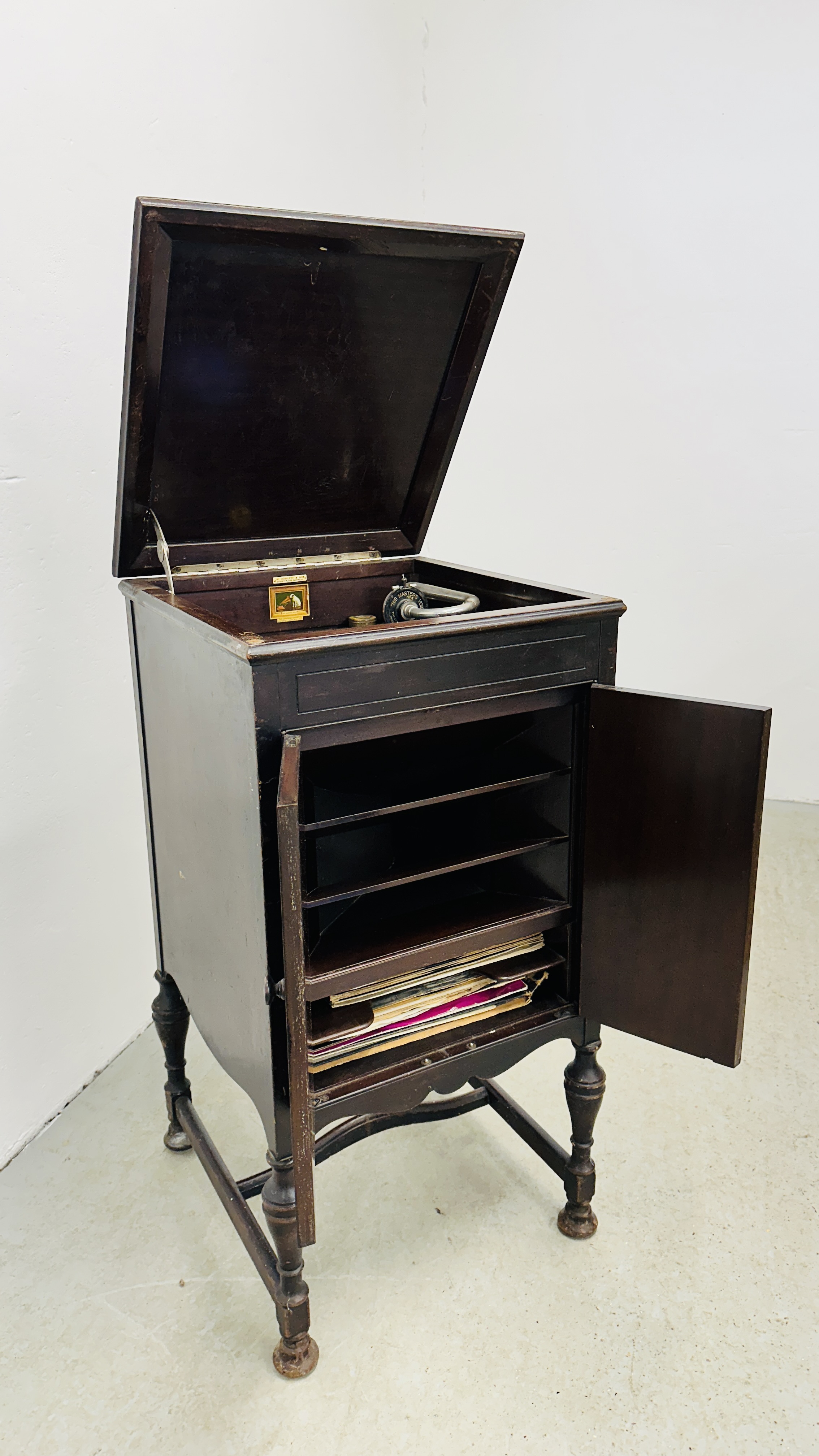 A VINTAGE "HIS MASTERS VOICE" GRAMOPHONE IN A FITTED MAHOGANY FINISH MUSIC CABINET BY W.