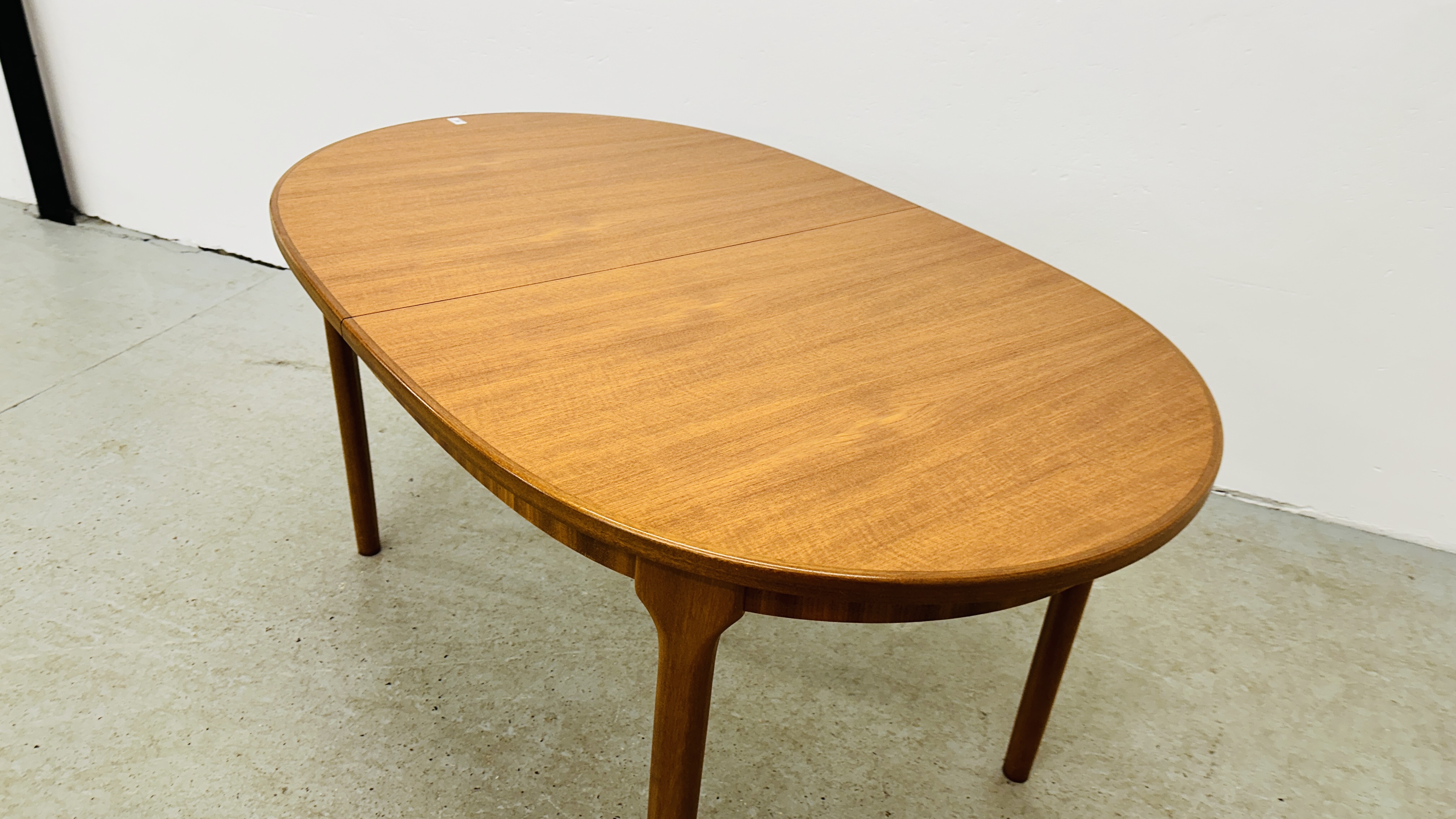 A MID CENTURY TEAK FINISH OVAL EXTENDING DINING TABLE BEARING ORIGINAL MAKERS LABEL "A.H. - Image 5 of 13