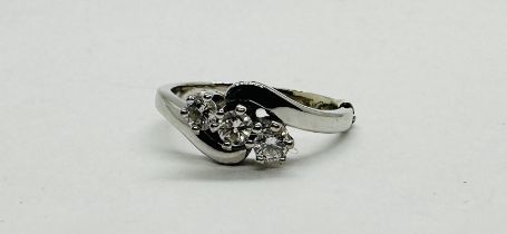 A CONTEMPORARY 18CT WHITE GOLD DIAMOND SET TRILOGY RING.