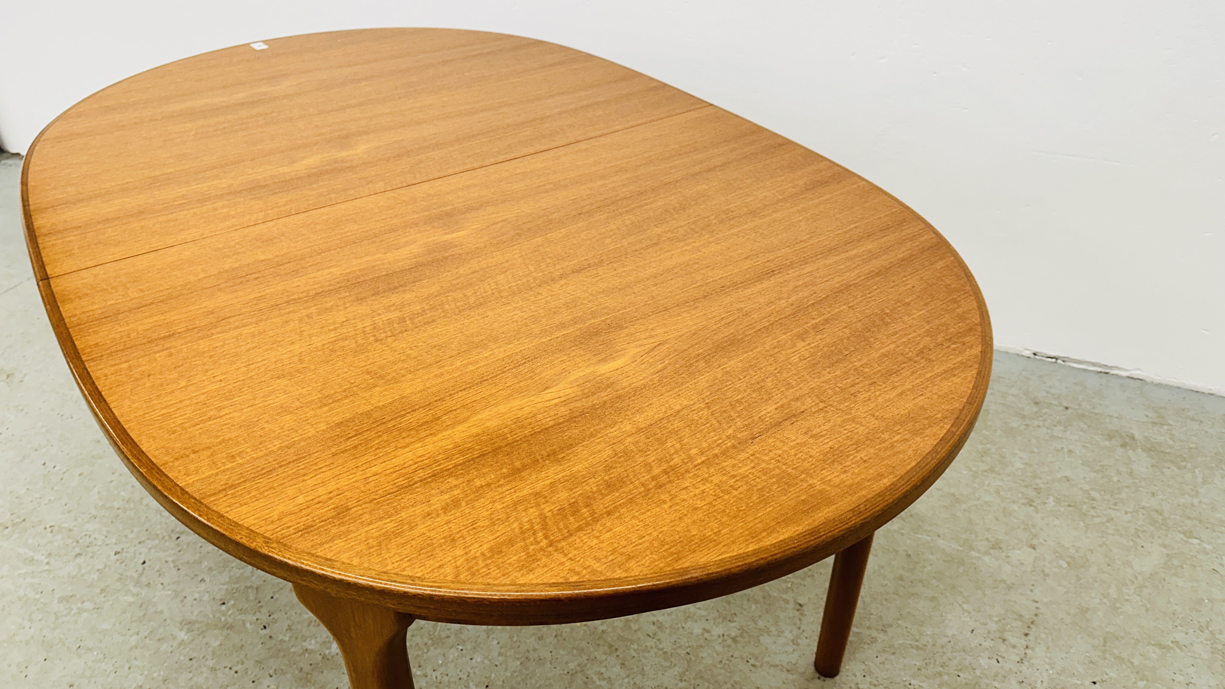 A MID CENTURY TEAK FINISH OVAL EXTENDING DINING TABLE BEARING ORIGINAL MAKERS LABEL "A.H. - Image 7 of 13