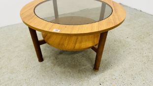 A RETRO CIRCULAR TEAK FINISH COFFEE TABLE WITH GLASS INSET TOP.