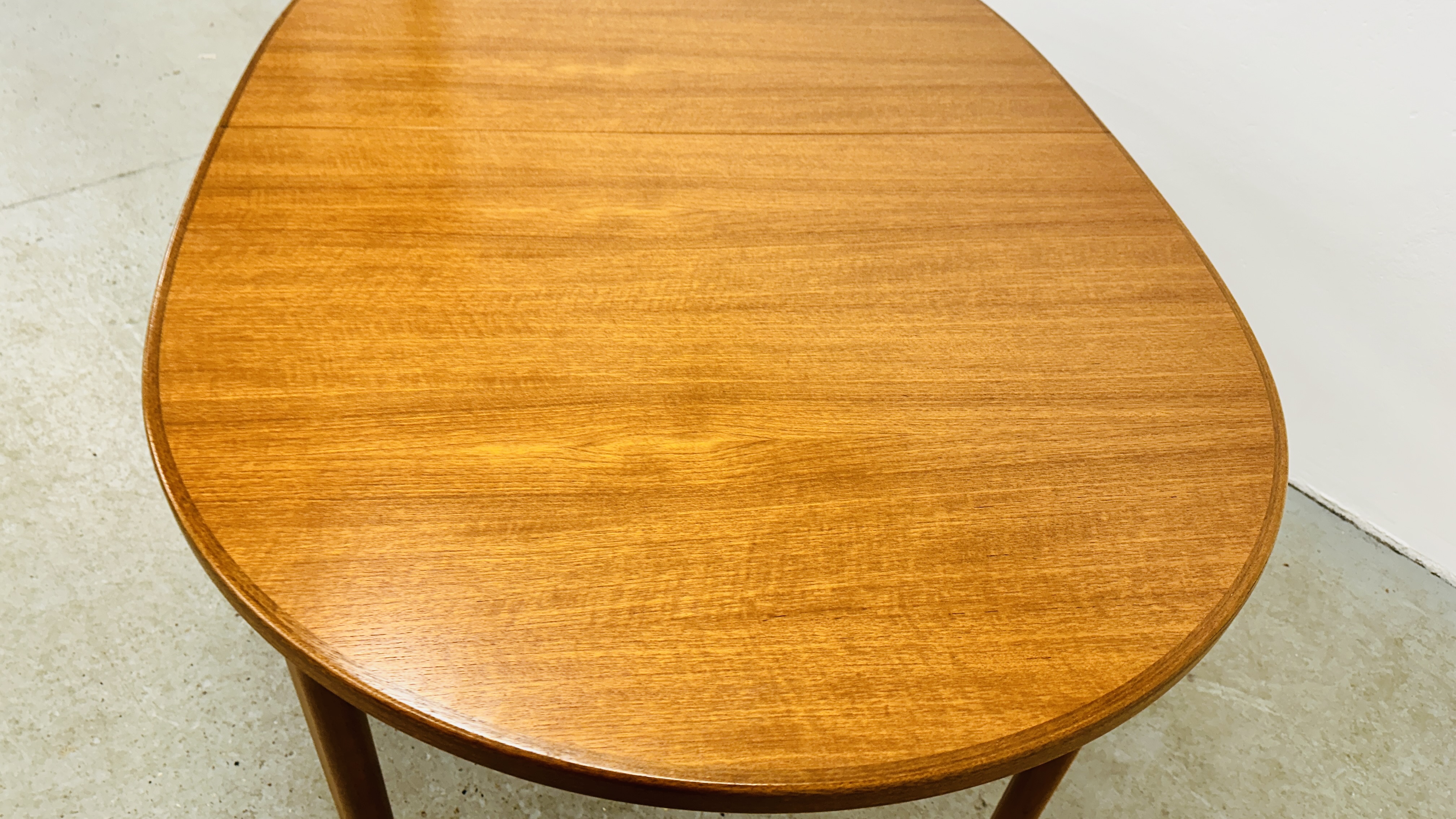 A MID CENTURY TEAK FINISH OVAL EXTENDING DINING TABLE BEARING ORIGINAL MAKERS LABEL "A.H. - Image 6 of 13