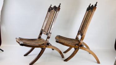 A PAIR OF UNUSUAL VICTORIAN WALNUT FOLDING CHAIRS, RATTAN SEAT AND BACK WITH CARVED TOP AND FINIALS,