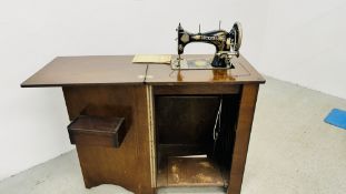 A VINTAGE VICKERS MODEL DELUX TREDDLE SEWING MACHINE IN FITTED MAHOGANY FINISH CUPBOARD WITH
