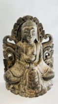 A CARVED WOODEN FIGURE OF AN EASTERN DEITY.