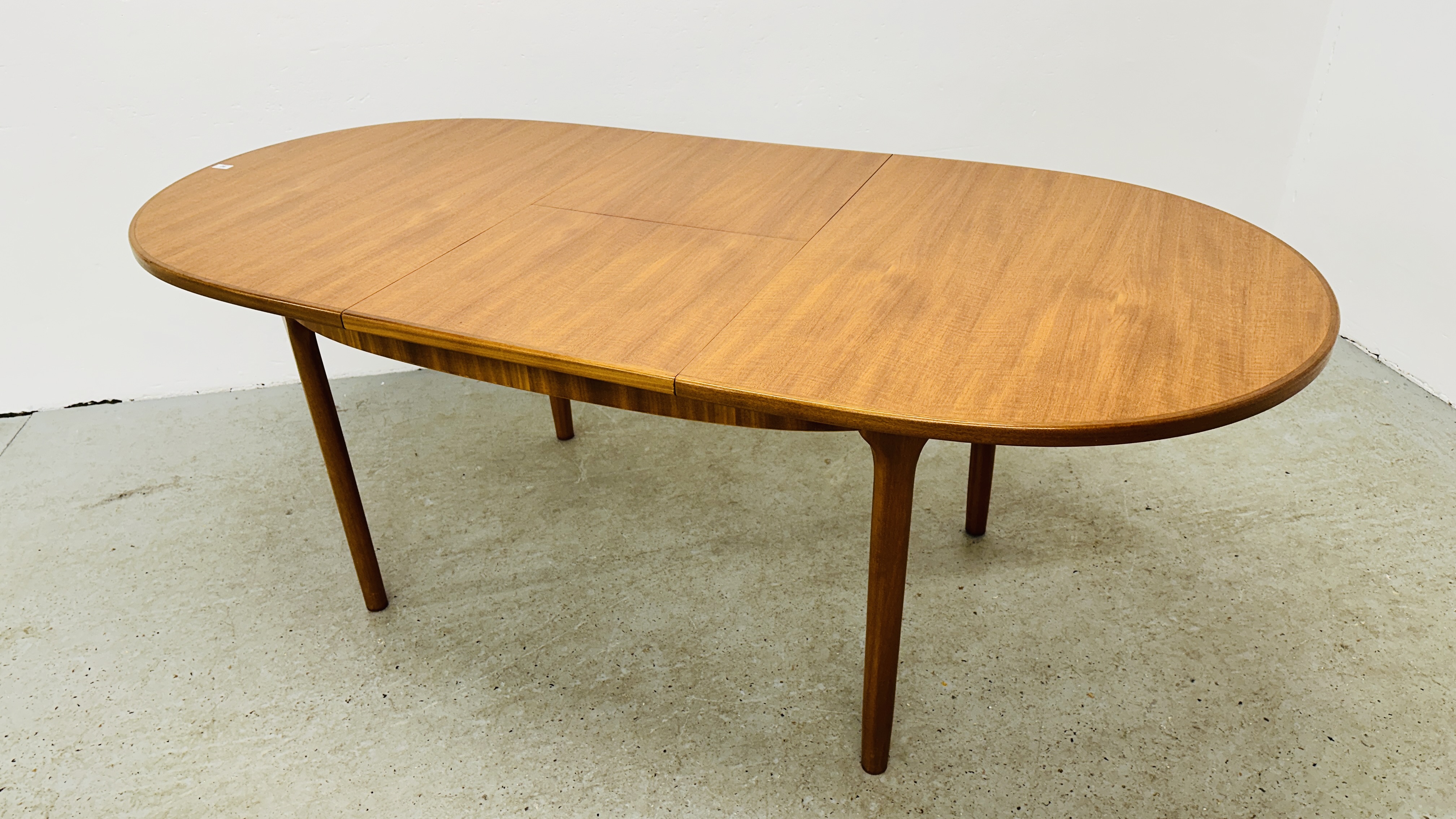 A MID CENTURY TEAK FINISH OVAL EXTENDING DINING TABLE BEARING ORIGINAL MAKERS LABEL "A.H. - Image 9 of 13