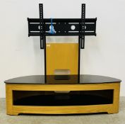A MODERN DESIGNER FLORENCE OVAL TV STAND WITH PIANO BLACK GLASS TOP AND SHELF OAK FINISH.