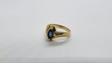 A 14K GOLD RING SET WITH 3 DIAMONDS AND A CENTRAL PALE BLUE STONE.