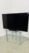 A SONY 48" FLAT SCREEN TV WITH 3 TIER GLASS STAND AND REMOTE - SOLD AS SEEN.