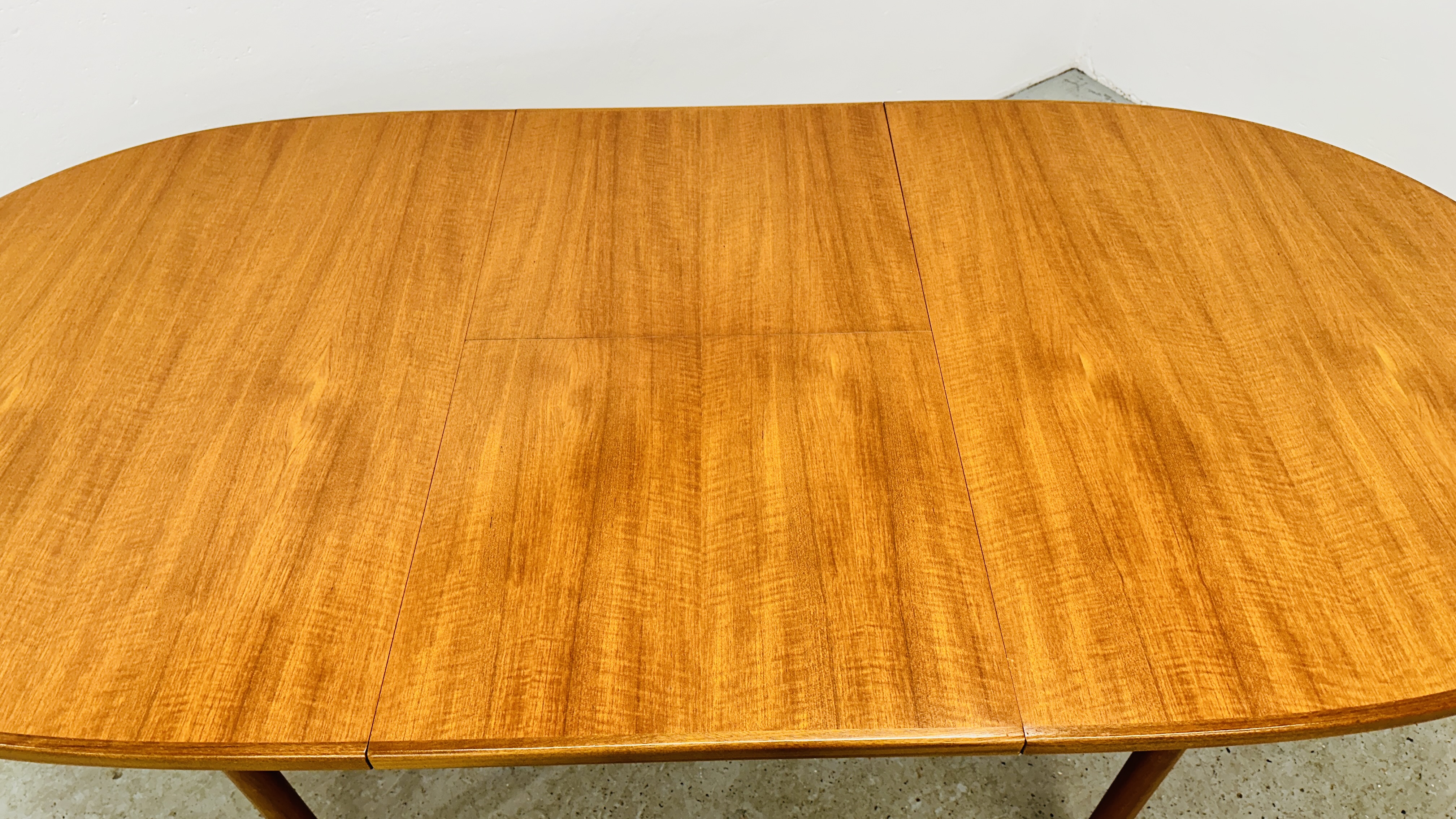 A MID CENTURY TEAK FINISH OVAL EXTENDING DINING TABLE BEARING ORIGINAL MAKERS LABEL "A.H. - Image 12 of 13