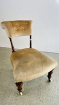 AN ANTIQUE VICTORIAN NURSING CHAIR ON TURNED LEGS AND CERAMIC CASTERS.