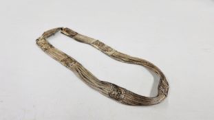 AN ELABORATE EASTERN WHITE METAL BELT OF WOVEN DESIGN THE CLASP MARKED WITH EASTERN SYMBOLS, L 60CM.