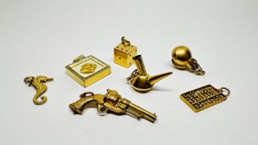 A GROUP OF SEVEN ASSORTED YELLOW METAL PENDANT CHARMS TO INCLUDE THREE EXAMPLES HAVING RUBBED MARKS.