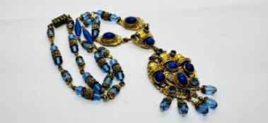 AN ELABORATE EASTERN GILT NECKLACE INSET WITH BLUE STONES, GLASS BEADS AND DROPS.