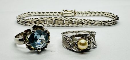A SILVER RING SET WITH BLUE STONE ALONG WITH ONE FURTHER WHITE METAL RING SET WITH SIMULATED PEARL