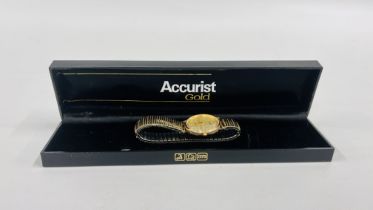 A GENTS 9CT GOLD CASED ACCURIST WRIST WATCH ON EXPANDABLE STRAP IN ORIGINAL BOX.