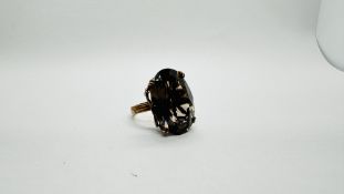 A RETRO 9CT GOLD SMOKEY QUARTZ RING, IN A DECORATIVE RAISED SETTING.