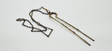 A VINTAGE YELLOW METAL HAIRPIN AND CHAIN.