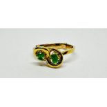 A MODERN CONTEMPORARY DESIGN RING MARKED 18CT SET WITH GREEN STONES - SIZE M/N.