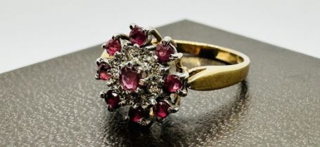A 9CT GOLD RUBY AND DIAMOND CLUSTER RING. SIZE P/Q.