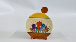 A CLARICE CLIFF BIZARRE BONJOUR JAM POT AND COVER, DECORATED WITH CROCUSES, 11CM HIGH.