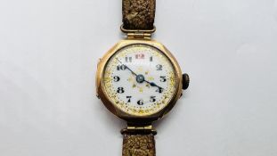 A VINTAGE 9CT GOLD WRIST WATCH WITH AN ORNATE ENAMELED DIAL ON A LEATHER STRAP.