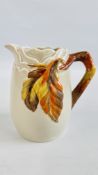 A CLARICE CLIFF (NEWPORT POTTERY) JUG WITH BRANCH HANDLE, DECORATED WITH THE AUTUMN LEAVES PATTERN,