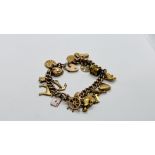 A 9CT GOLD CHARM BRACELET WITH SAFETY CHAIN AND PADLOCK CLASP ALONG WITH 18 9CT CHARMS AND A