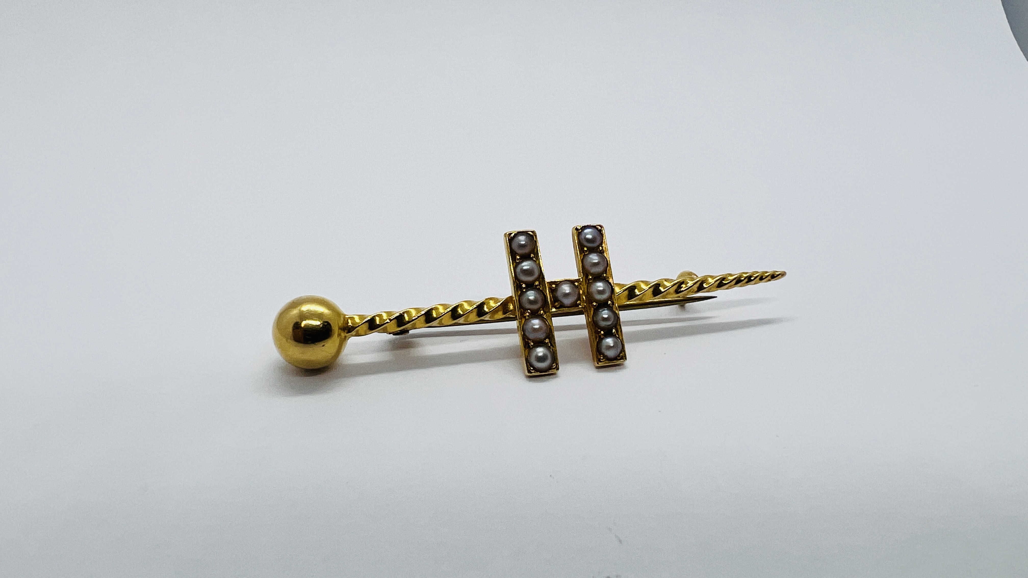 AN 18CT GOLD BAR BROOCH WITH MONOGRAM H SET WITH 11 SEED PEARLS.