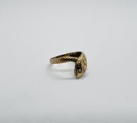 A 9CT GOLD SNAKE RING THE EYES SET WITH GARNET.