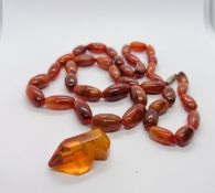 AN AGATE STRAND NECKLACE L70CM ALONG WITH AN AMBER TYPE CURIO.